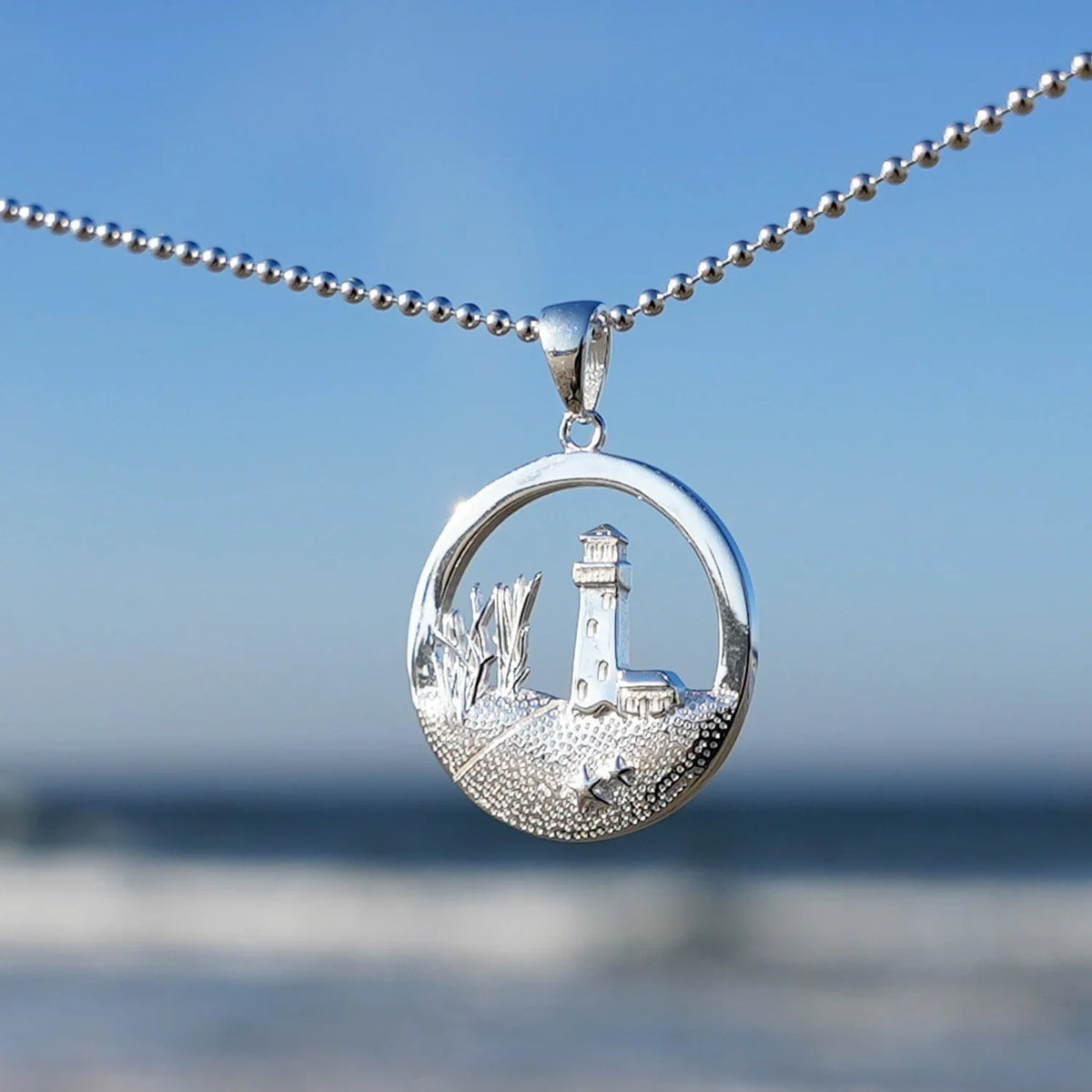 Silberner Kettenanhänger mit Leuchtturm und Dünen, maritimer Schmuck am Strand