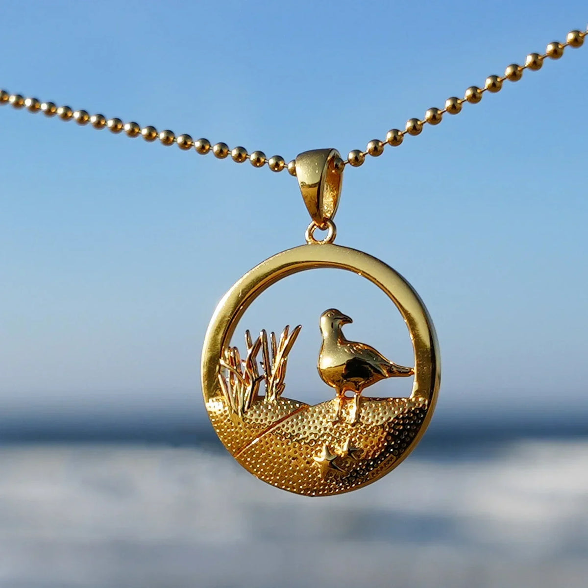 Goldene Kette mit Möwen-Anhänger, maritimes Schmuckdesign, Strand und Dünenmotiv