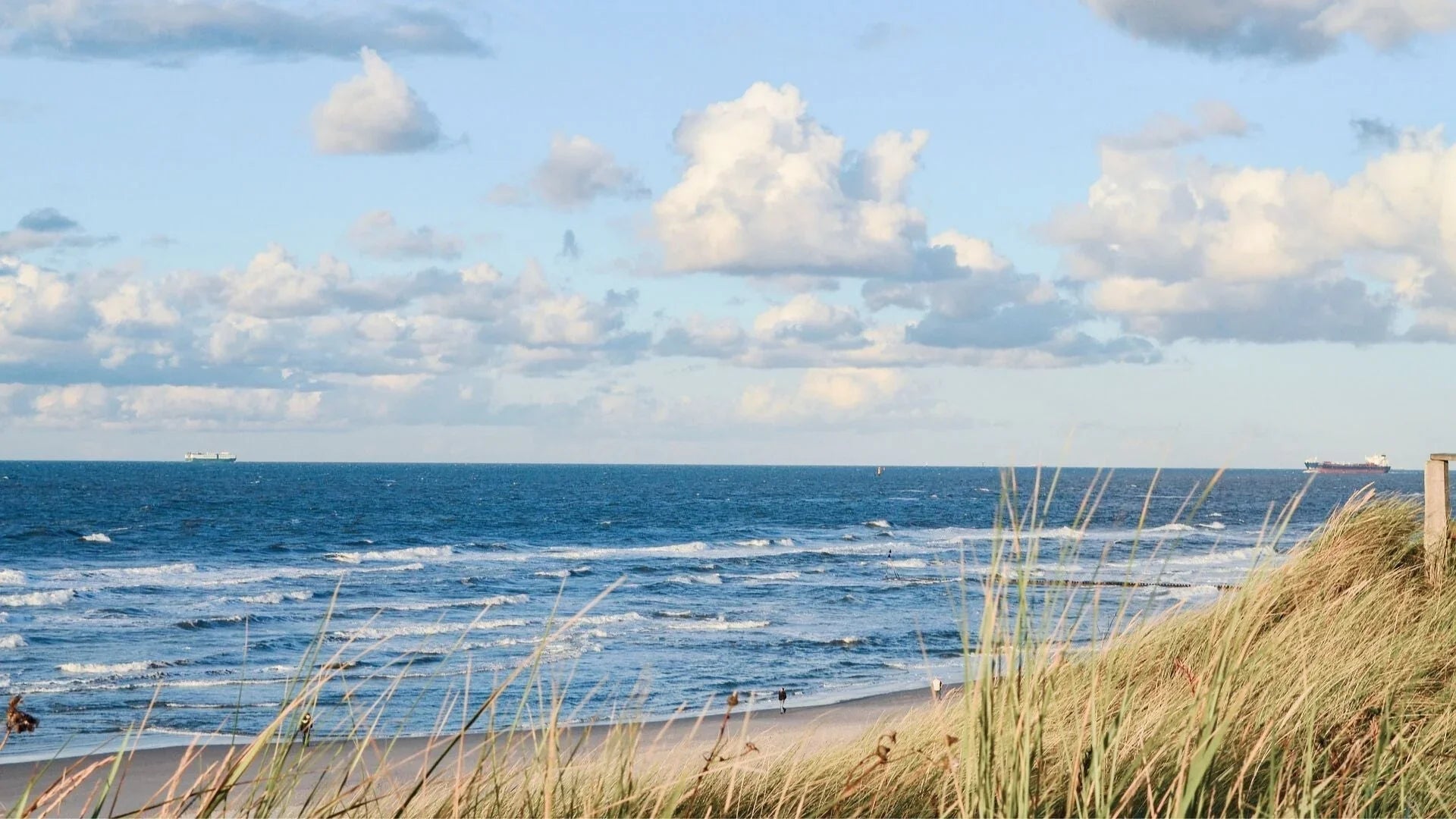 Nordsee Strand mit Dünen, Wellen und weitem Himmel in Nordfriesland, Urlaubsidylle