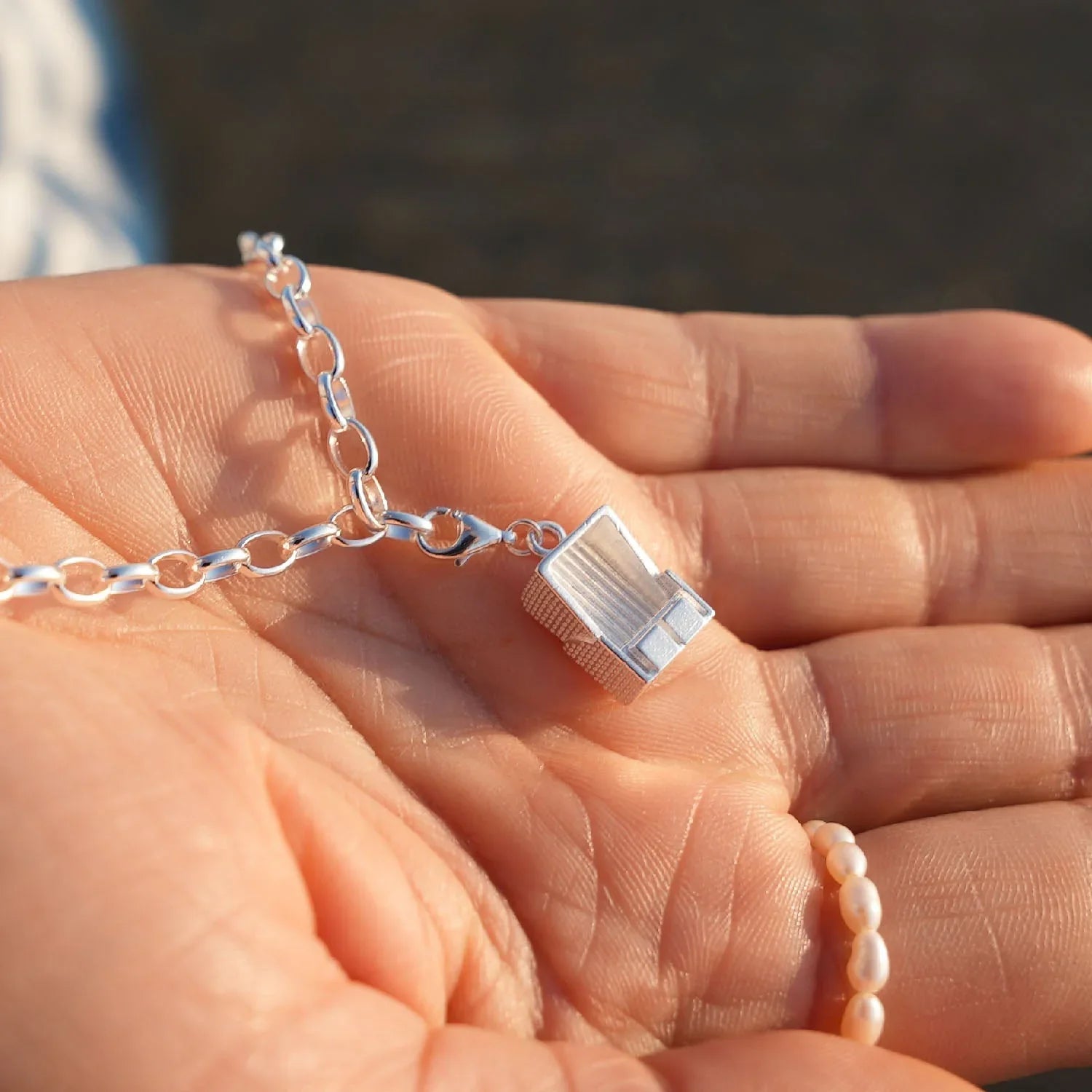 Silbernes Armband mit Strandkorb-Charm, maritimer Schmuck, Nahaufnahme auf Hand