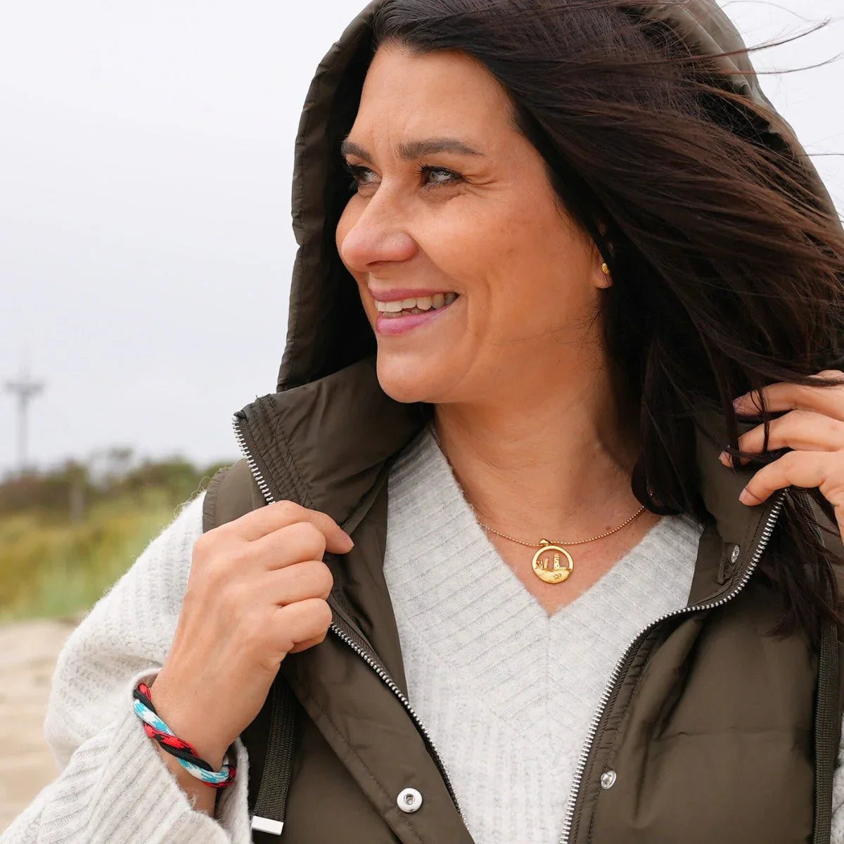 Frau am Strand mit maritimem Armband Wattenmeer und goldener Kette, Outdoor-Look