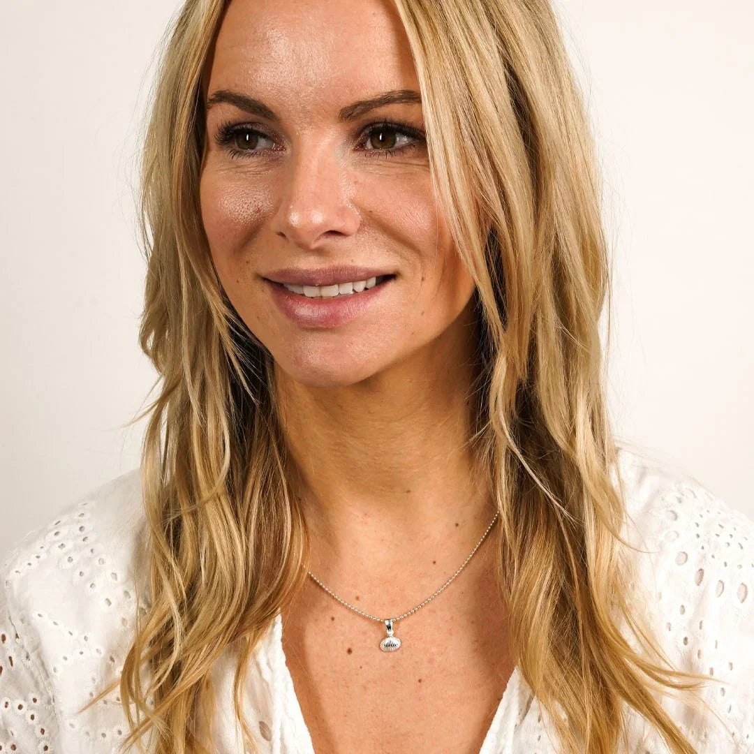 Frau mit silberner Halskette und Herzmuschel-Anhänger, maritimer Schmuck