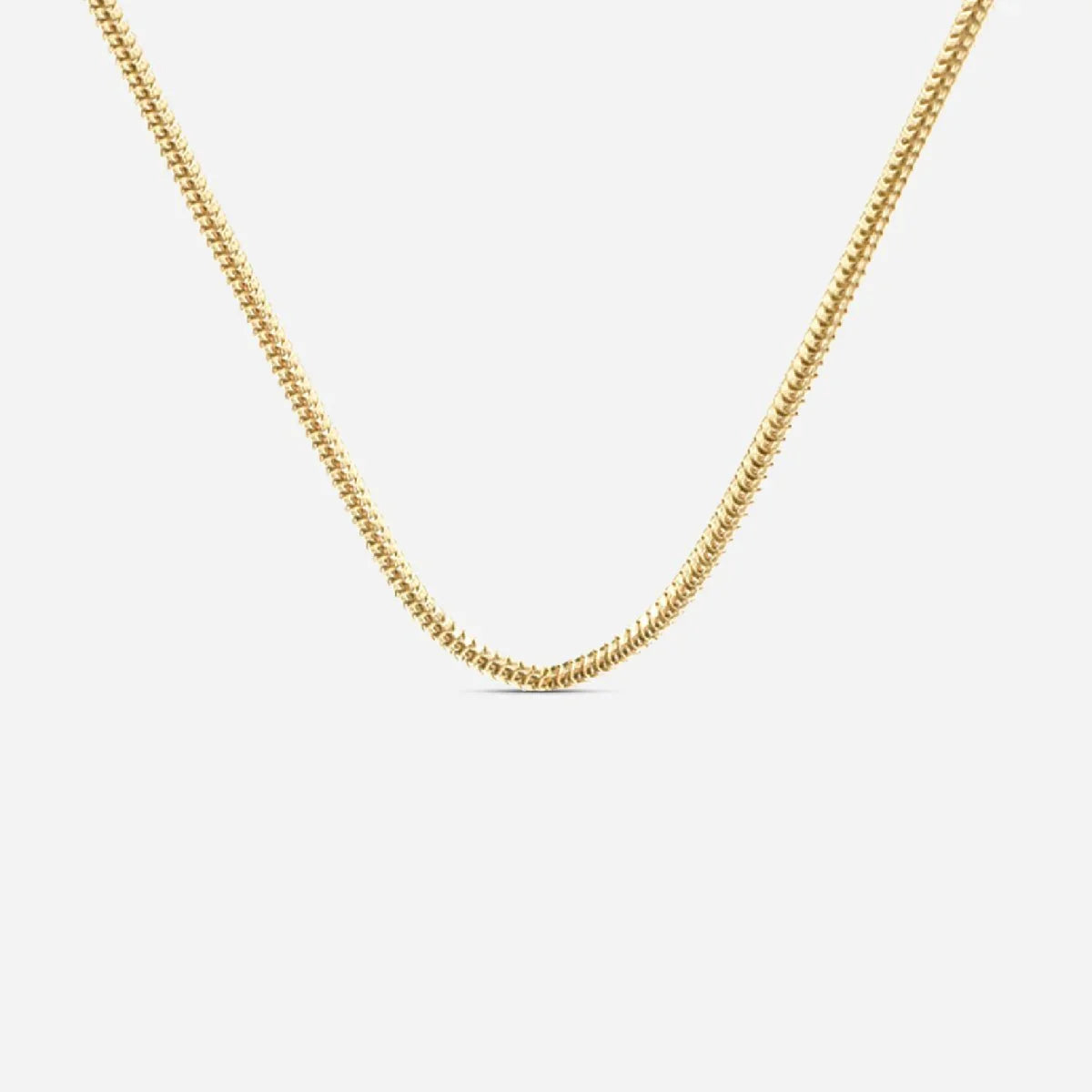 Feingliedrige goldene Kette aus Edelstahl vor weißem Hintergrund, moderner Schmuck