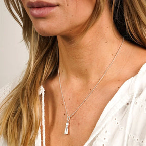 Frau trägt maritime Silberkette mit Leuchtturm-Anhänger am Hals, Küstenschmuck