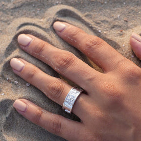 Silberner Ring mit Gravur 'Meer' an Hand im Sand, maritimer Schmuck, Strandmotiv