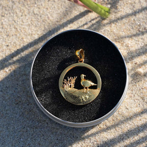 Goldener Anhänger mit Möwe und Dünenmotiv im Sand, maritimer Schmuck für Strandliebhaber
