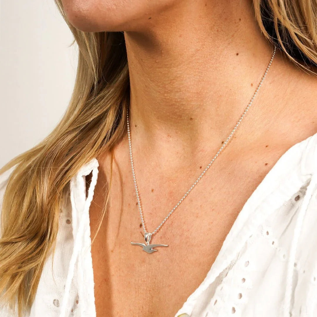 Silberne Kette mit Möwe-Anhänger, getragen am Hals einer Frau, maritimer Schmuckstil