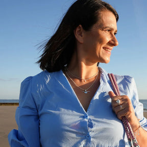 Frau mit silberner Möwenkette am Strand, maritimer Schmuck, Sommer, blauer Himmel