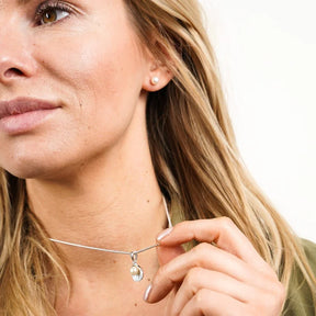 Frau trägt Kette mit silbernem Muschel-Anhänger und Perle, maritimer Schmuck