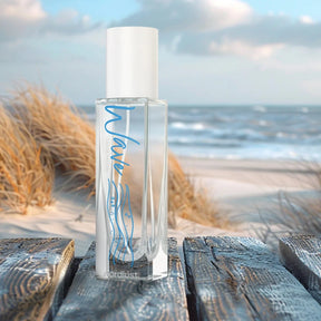 Parfümflakon Wave Eau de Parfum 15ml am Strand mit Meer und Dünen im Hintergrund