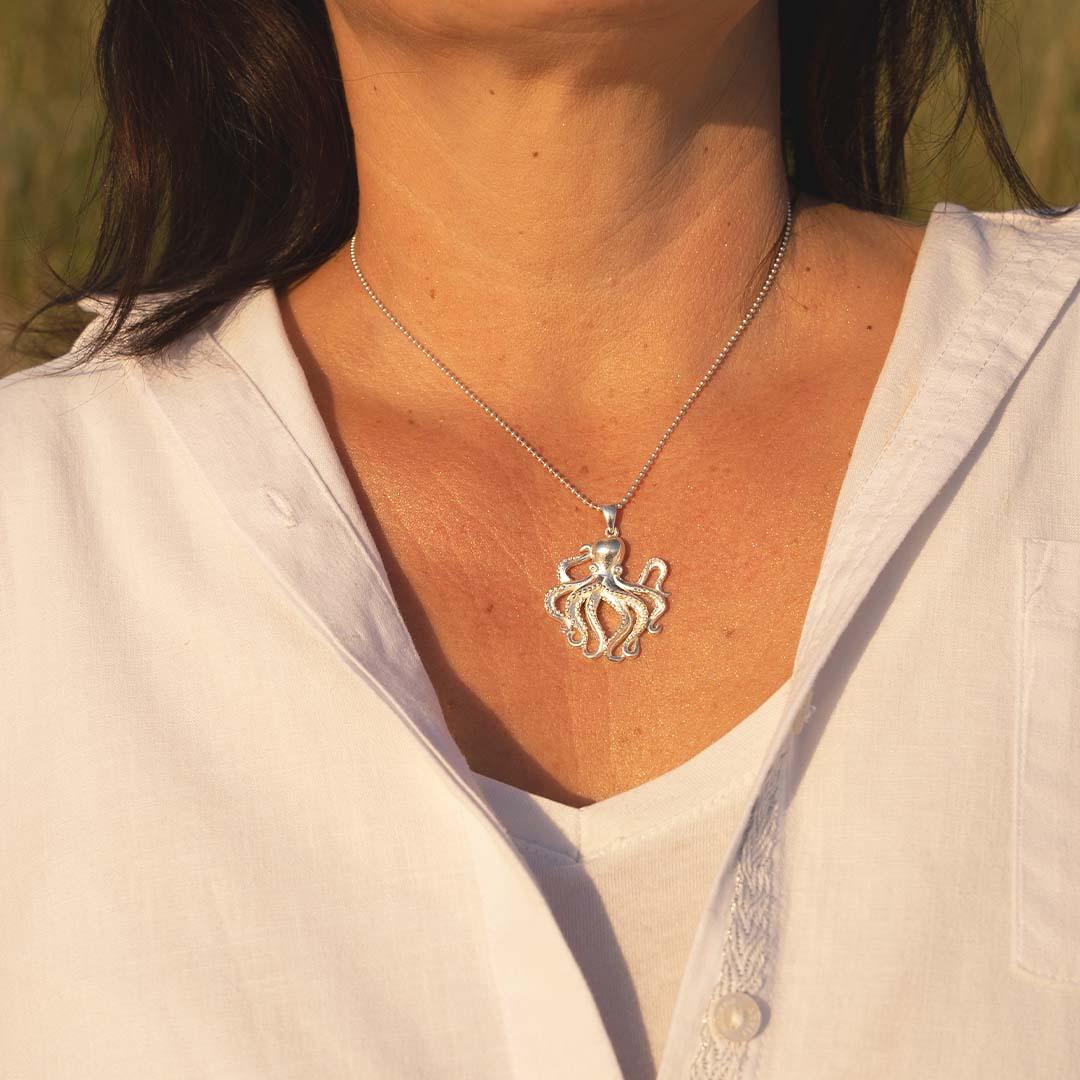 Silberne Oktopus-Kette als maritimer Schmuckanhänger an einer Frau mit weißer Bluse