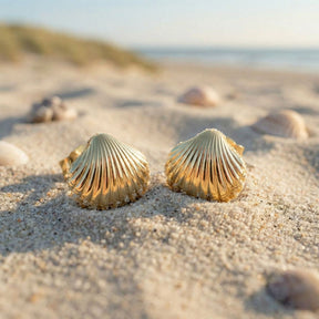 Goldene Herzmuschel Ohrstecker im Sand am Strand, maritimer Schmuck, Muschel-Design
