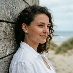 Frau mit silbernen Seestern-Ohrsteckern am Strand, maritime Schmuck Ohrringe