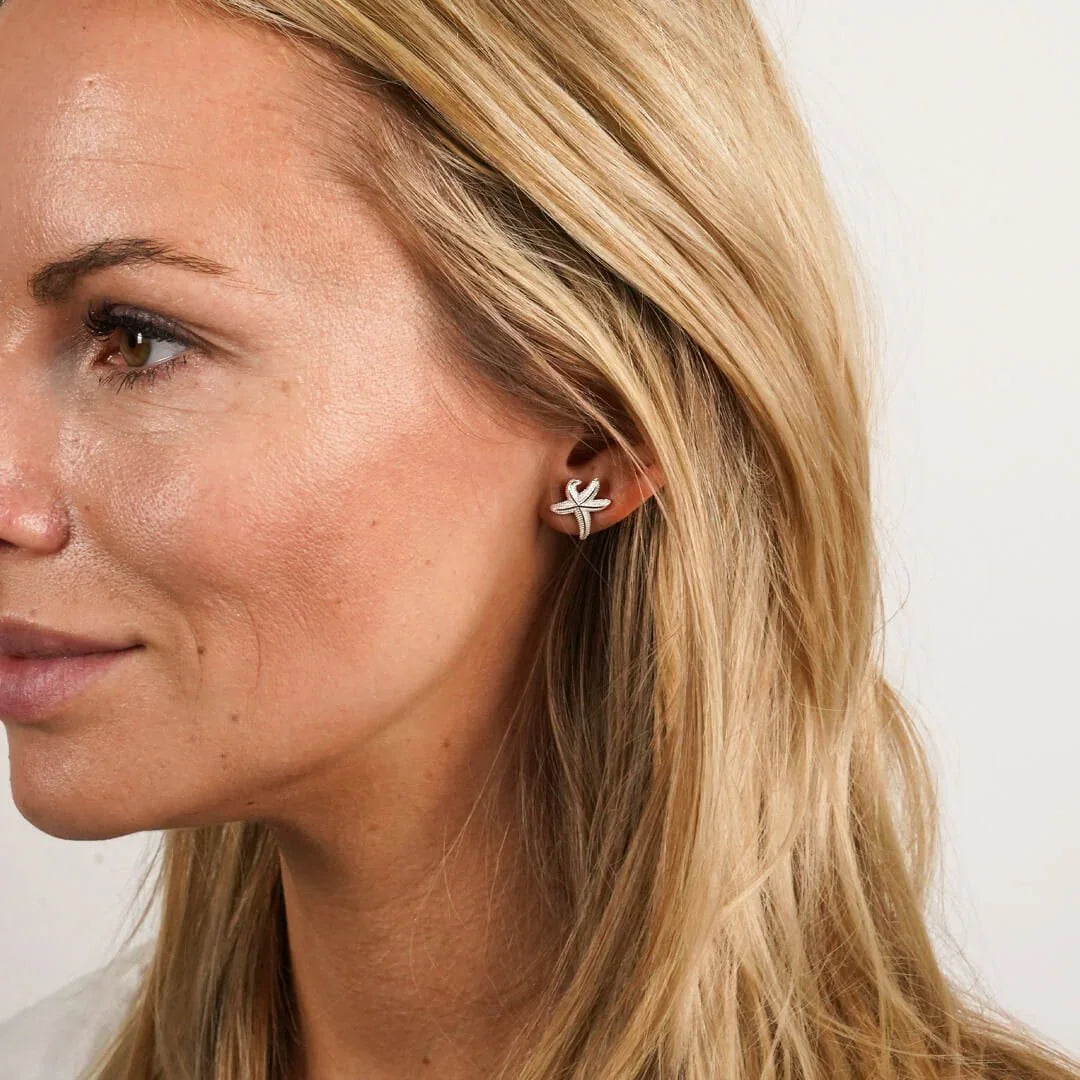 Frau mit silbernem Seestern Ohrstecker, maritimer Schmuck, Nahaufnahme