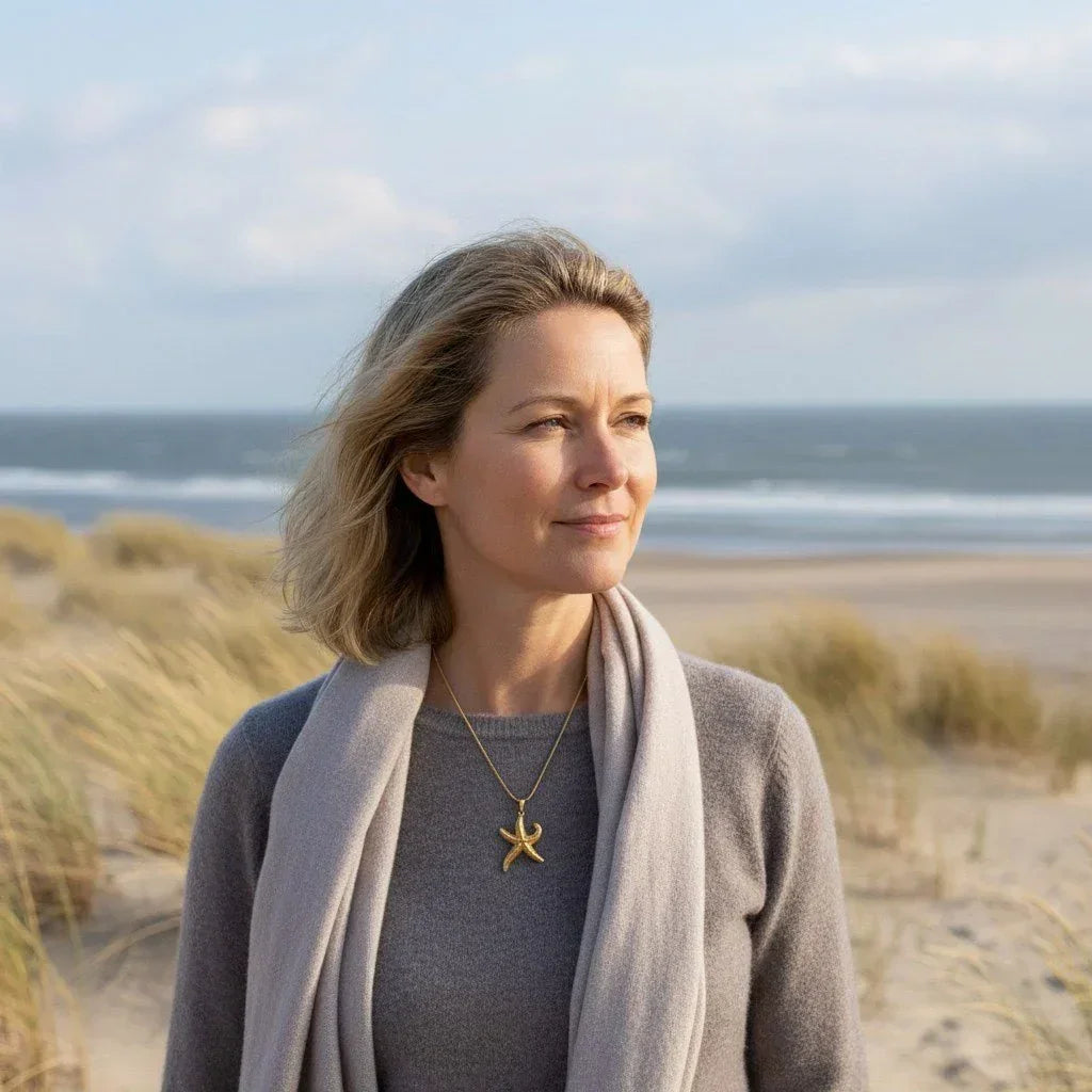 Frau am Strand trägt goldene Seestern-Kette, maritimer Schmuck, Küstenstil