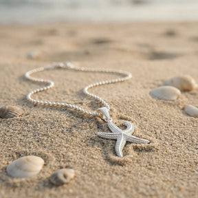 Silberne Seestern-Kette am Strand mit Muscheln, maritimer Schmuck, Nahaufnahme