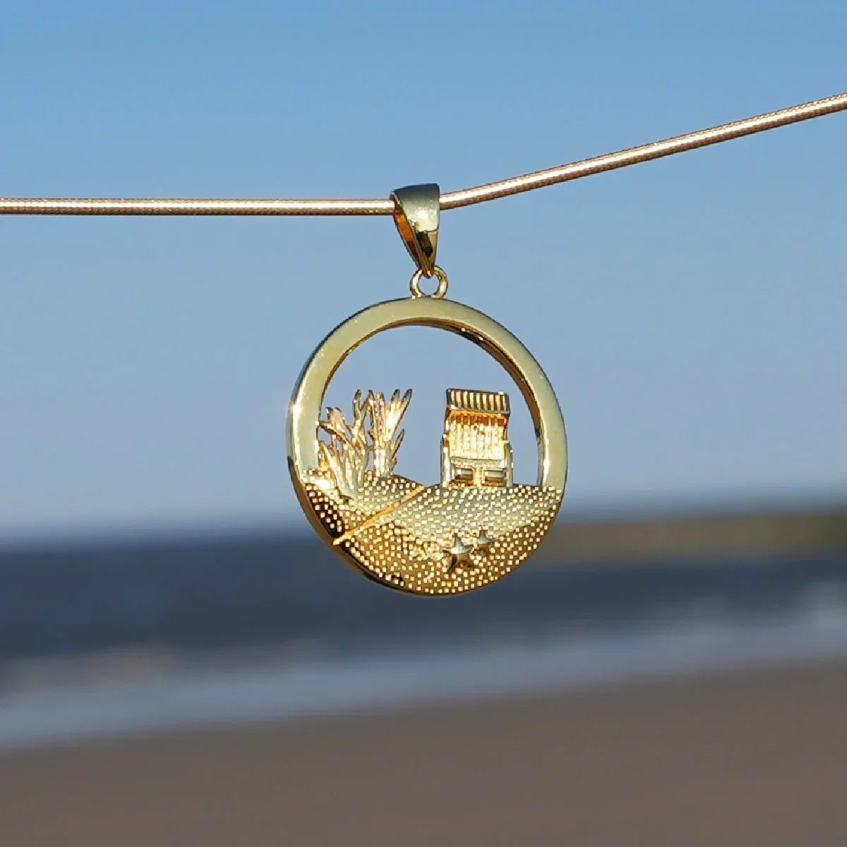 Goldener Anhänger mit Dünen, Strandkorb und Seestern am maritimen Strandmotiv
