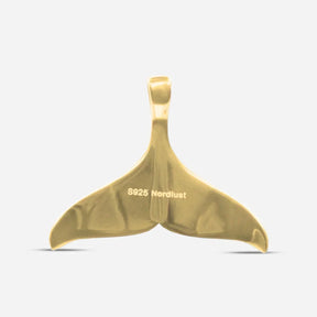 Goldener Anhänger in Form einer Walflosse, maritimer Schmuck, Nahaufnahme auf weißem Hintergrund