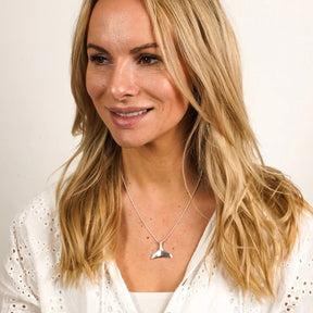 Frau mit silberner Walflossen-Kette, maritimer Schmuck, weißes Oberteil