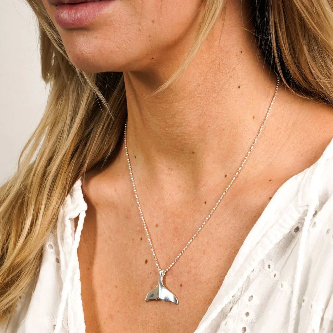 Silberne Walflosse Halskette an Frau, maritimer Schmuck, Meer-Motiv, Nahaufnahme